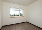 Thumbnail 24 of 36 - A room with a window and wooden flooring.