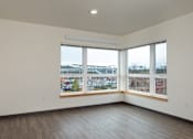 Thumbnail 26 of 36 - A large empty room with a view of a parking lot through the windows.