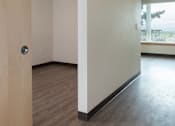 Thumbnail 29 of 36 - A room with a white wall and a wooden floor.