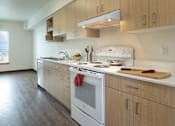 Thumbnail 3 of 36 - A kitchen with a white oven and wooden cabinets.