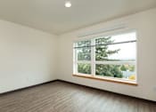 Thumbnail 30 of 36 - A room with a window overlooking a tree.