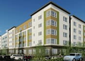 Thumbnail 33 of 36 - A modern apartment building with cars parked in front.