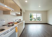 Thumbnail 4 of 36 - A kitchen with a stove top oven and a window.