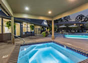 Thumbnail 3 of 10 - A swimming pool is surrounded by a patio with chairs and a table.