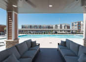 Thumbnail 3 of 17 - A large outdoor seating area with a pool and apartment buildings in the background at Woodstone at Metro North Crossing Apartments, Kansas City, Missouri