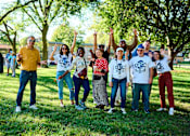 Thumbnail 22 of 24 - A group of people wearing white t-shirts with the text "CBC" are standing in a park.