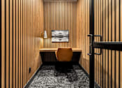 Thumbnail 19 of 24 - A room with a wooden wall and a chair.
