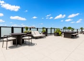Thumbnail 8 of 40 - A patio with a table and chairs overlooking a cityscape.