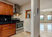 Thumbnail 5 of 23 - A kitchen with wooden cabinets and a black countertop.