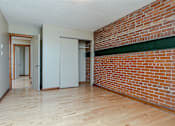 Thumbnail 8 of 23 - A room with a brick wall and wooden flooring.