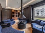 Thumbnail 36 of 39 - A modern living room with a fireplace and blue couches.