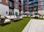 Thumbnail 40 of 40 - A patio area with a white couch and a green lawn.
