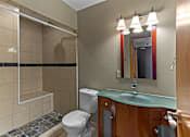 Thumbnail 19 of 23 - A bathroom with a toilet, sink, and mirror.