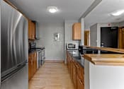 Thumbnail 23 of 23 - A kitchen with wooden cabinets and stainless steel appliances.