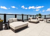 Thumbnail 9 of 40 - A patio with white furniture and a black railing.