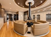 Thumbnail 2 of 40 - A modern living room with a large circular table and a fireplace.