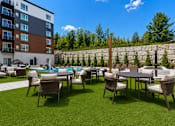 Thumbnail 11 of 40 - A patio with a table and chairs is surrounded by a stone wall.