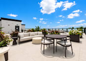 Thumbnail 5 of 40 - A patio with a table and chairs overlooking a body of water.
