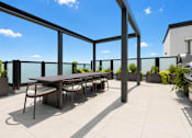Thumbnail 6 of 40 - A table surrounded by chairs on a patio.