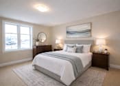Thumbnail 20 of 20 - A bedroom with a large bed, two nightstands, and a painting on the wall.