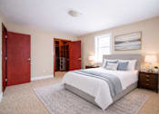 Thumbnail 5 of 20 - A bedroom with a large bed and a red door.
