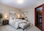 Thumbnail 4 of 20 - A bedroom with a large bed and a potted plant.