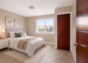 Thumbnail 9 of 22 - A bedroom with a bed, nightstand, and window.