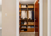 Thumbnail 7 of 22 - A wooden wardrobe with clothes and baskets on the shelves.