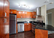 Thumbnail 2 of 20 - A kitchen with wooden cabinets and a black countertop.