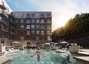 Thumbnail 21 of 24 - A woman is swimming in a pool surrounded by apartment buildings at The Woods at 180 Kanata Avenue, Kanata, K2K 3L9