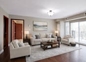 Thumbnail 16 of 20 - A living room with a white couch, a coffee table, and a painting on the wall.