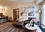 Thumbnail 11 of 17 - a living room with a wooden dining table and white couches at 150 Marketplace, Ontario