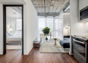 Thumbnail 10 of 17 - a bedroom with a bed and a tv in a room with hardwood floors at 150 Marketplace, Ottawa, ON, K2J 5R5