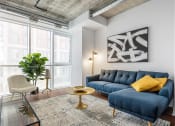 Thumbnail 9 of 17 - a living room with a blue couch and yellow pillows at 150 Marketplace, Ottawa, ON