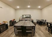 Thumbnail 28 of 28 - Creekside Common room large wooden table with chairs in a room with white walls and hardwood floors