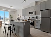 Thumbnail 3 of 24 - A modern kitchen with a refrigerator, microwave, and stove at The Woods at 180 Kanata Avenue, Ontario, K2K 3L9