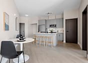 Thumbnail 13 of 24 - A modern kitchen with a dining table and chairs at The Woods at 180 Kanata Avenue, Kanata, ON, K2K 3L9
