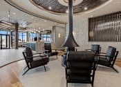 Thumbnail 27 of 34 - A modern lounge area with black chairs and a wooden floor at The Woods at 180 Kanata Avenue Apartments, Kanata