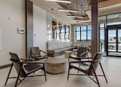 Thumbnail 33 of 34 - Four chairs are arranged around a table in a room with a glass wall at The Woods at 180 Kanata Avenue Apartments, Kanata, Ontario