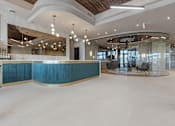 Thumbnail 29 of 34 - A modern interior with a curved reception desk and a bar area at The Woods at 180 Kanata Avenue Apartments, Ontario, K2T 0T4