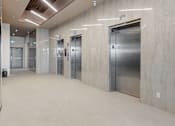 Thumbnail 28 of 34 - A long hallway with elevators on the side at The Woods at 180 Kanata Avenue Apartments, Ontario