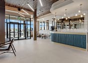 Thumbnail 21 of 34 - A reception area with a curved reception desk and a chair at The Woods at 180 Kanata Avenue Apartments, Kanata