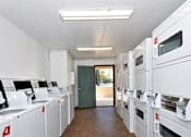 Thumbnail 13 of 17 - A row of white appliances are lined up in a room.