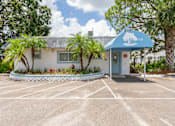 Thumbnail 19 of 19 - A small building with a blue awning is surrounded by a parking lot.
