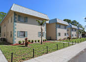 Thumbnail 16 of 17 - A row of houses with a sidewalk and a fence in front.