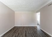 Thumbnail 7 of 20 - A room with wooden flooring and white walls.