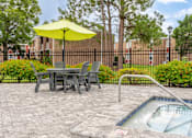 Thumbnail 16 of 20 - A patio with a table, chairs, and a pool.