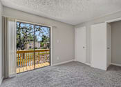 Thumbnail 24 of 39 - A room with a sliding glass door leading to a balcony.