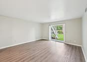 Thumbnail 6 of 55 - Empty room with wooden floor and sliding glass door.