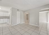 Thumbnail 37 of 39 - A spacious room with white walls and tile flooring.